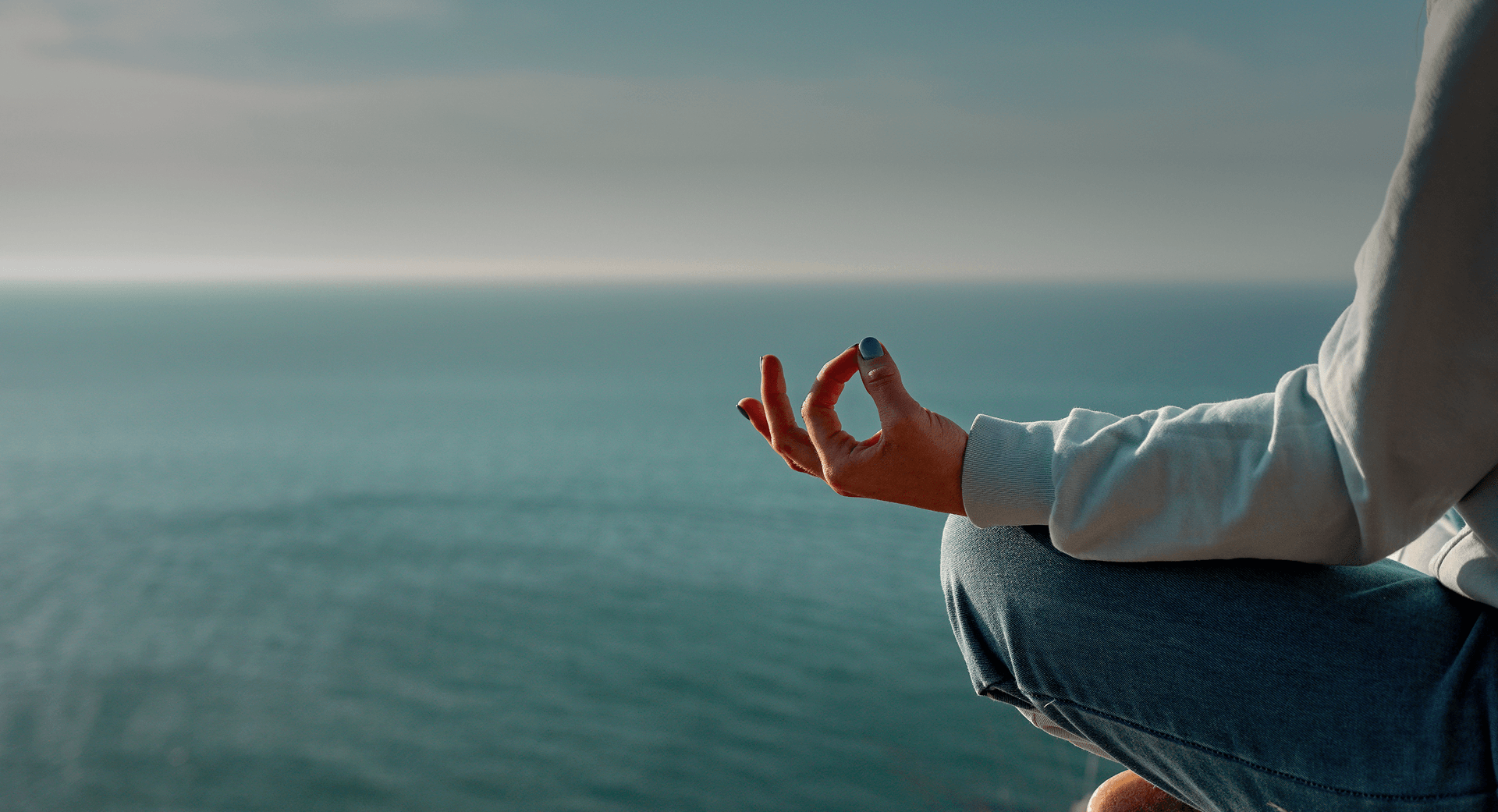 Person meditating by the ocean